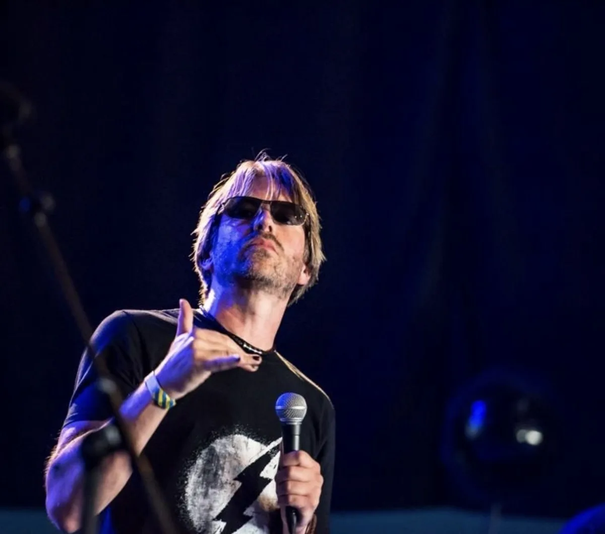 Alex Vigay performing on stage with a microphone